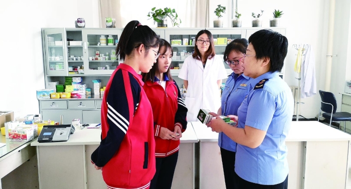 圖為執(zhí)法人員向?qū)W生普及安全用藥知識(shí)。