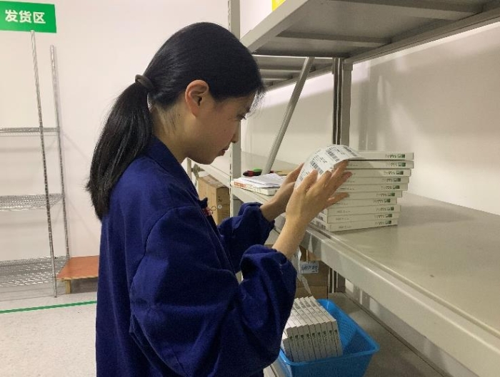 圖為金華市中心醫(yī)院工作人員將追溯二維碼粘貼到醫(yī)療器械包裝盒上。何璇 攝