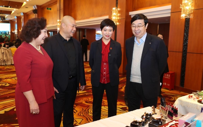 新疆維吾爾自治區藥品監督管理局黨組成員、副局長馬明輝（右一）了解新疆化妝品企業的產品（馬少賓 攝）