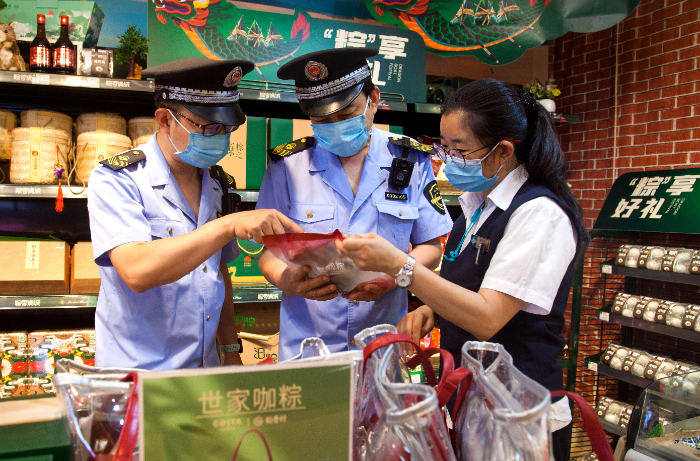 東城區(qū)市場(chǎng)監(jiān)管局執(zhí)法人員在超市檢查粽子保質(zhì)期。