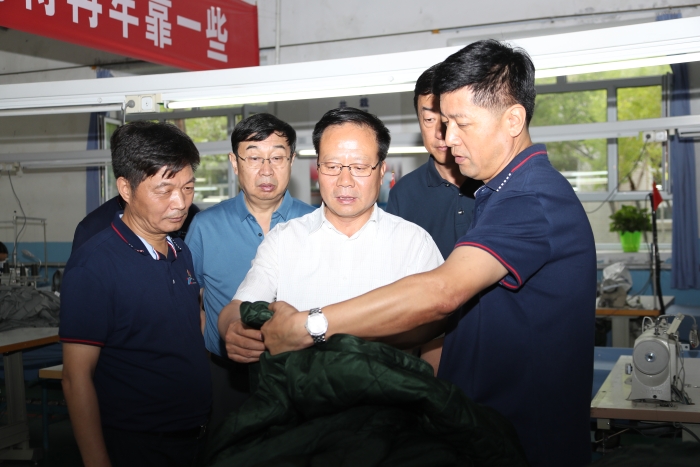 新疆維吾爾自治區藥監局黨組書記、局長張鈺祥（左三）帶隊在昌吉州調研防護服生產企業。局黨組成員、副局長馬明輝（左二）陪同調研。（馬少賓攝）