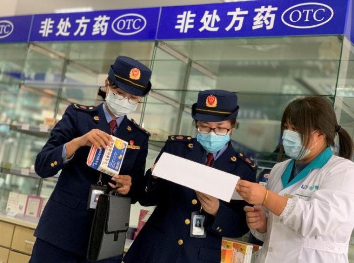 圖為該局執法人員對發燒類藥品銷售登記進行檢查。