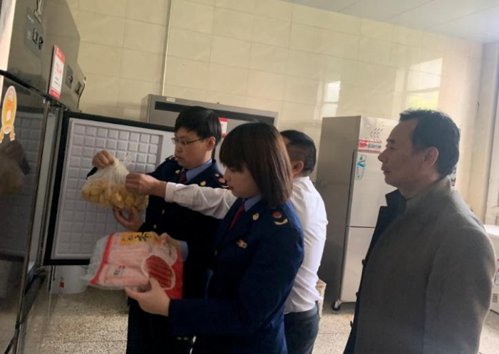 圖為該局執(zhí)法人員檢查學校食堂食品原料。