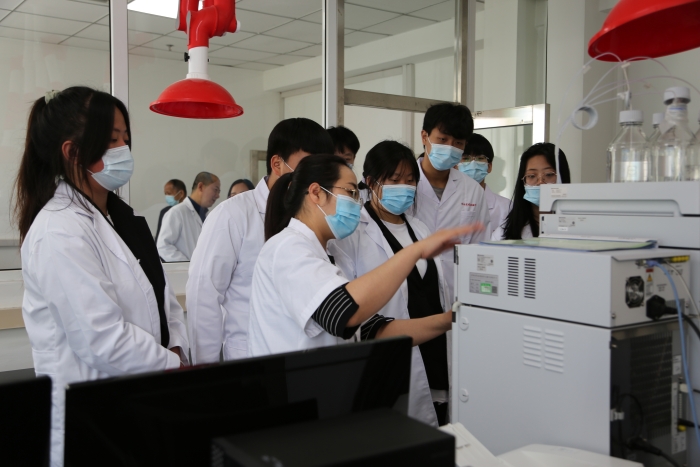 圖為工作人員介紹化妝品檢驗設備使用方法。