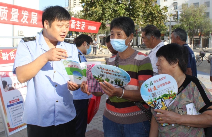 圖為執法人員向群眾宣講食品安全知識。