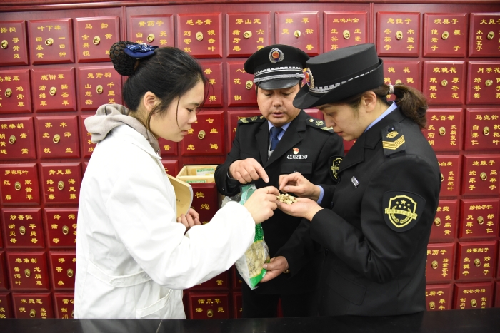 圖為執法人員正在一家企業檢查中藥飲片質量。