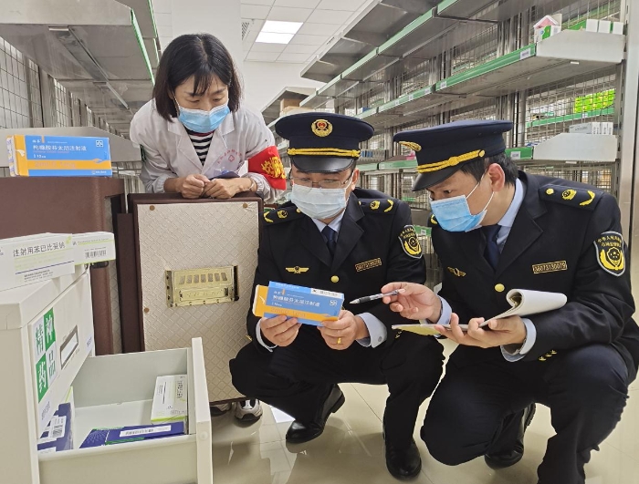 圖為2月12日該執法人員正在一零售藥店檢查藥品