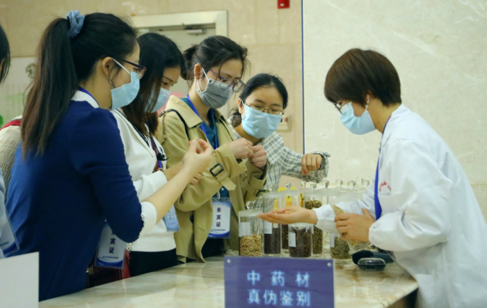 圖為工作人員為市民代表講解中藥材鑒別知識(shí)。