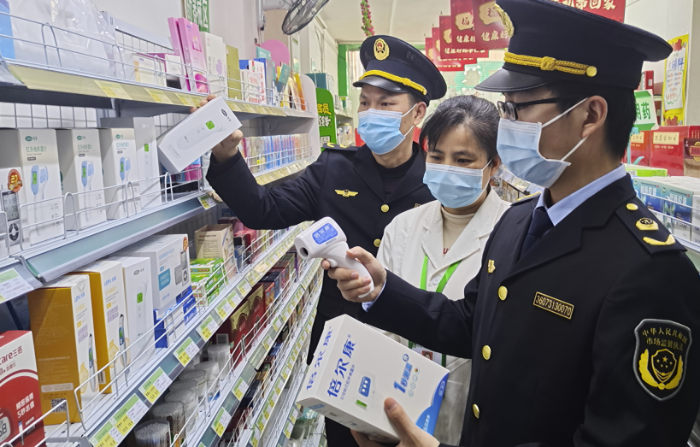 圖為執法人員在一家藥店檢查額溫槍。