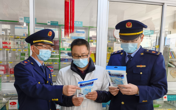 圖為執(zhí)法人員檢查藥店防疫物資。