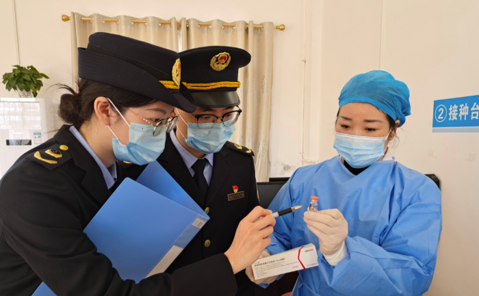圖為執(zhí)法人員在一家醫(yī)院檢查新冠疫苗和抗原檢測試劑。