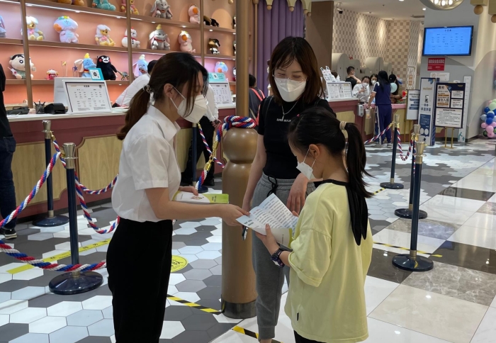 圖為工作人員向兒童發(fā)放兒童化妝品品科普資料（葉陽(yáng)歡攝）