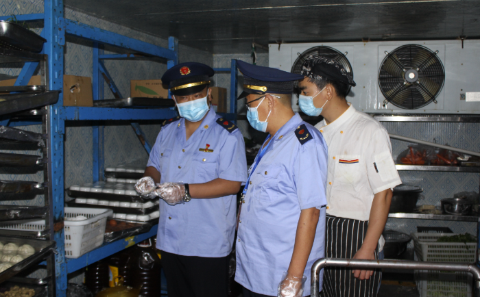 圖為該局執法人員在一學校食堂檢查食品安全制度落實情況。