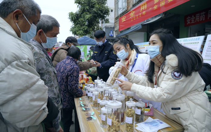 圖為工作人員現(xiàn)場(chǎng)向群眾講解常用中藥材的鑒別知識(shí)，普及藥品安全相關(guān)法律法規(guī)。