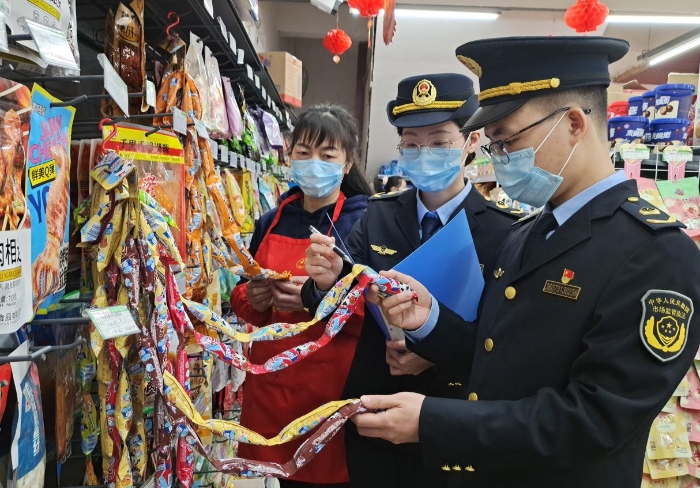 圖為2月1日該局執(zhí)法人員在校園周邊商店內(nèi)檢查小食品。