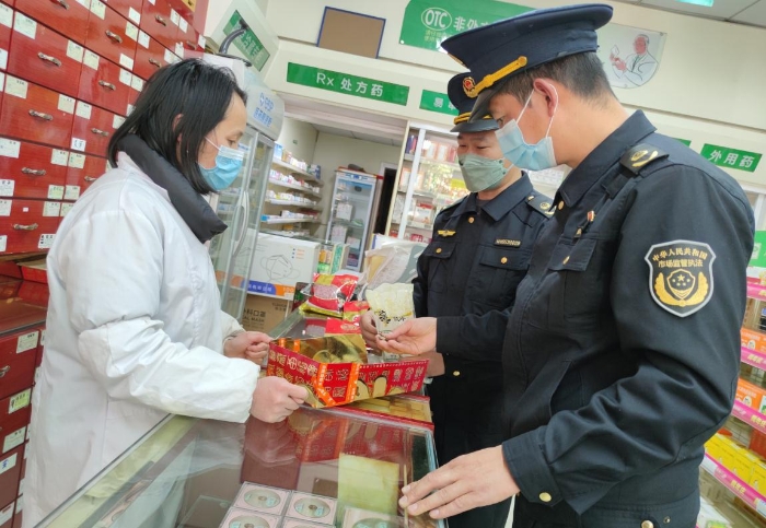 圖為執(zhí)法人員在一家零售藥店檢查中藥飲片是否霉?fàn)€變質(zhì)。