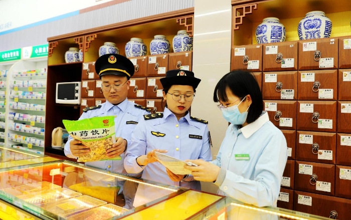 圖為4月25日，執法人員在對一家零售藥店的中藥飲片進行檢查。