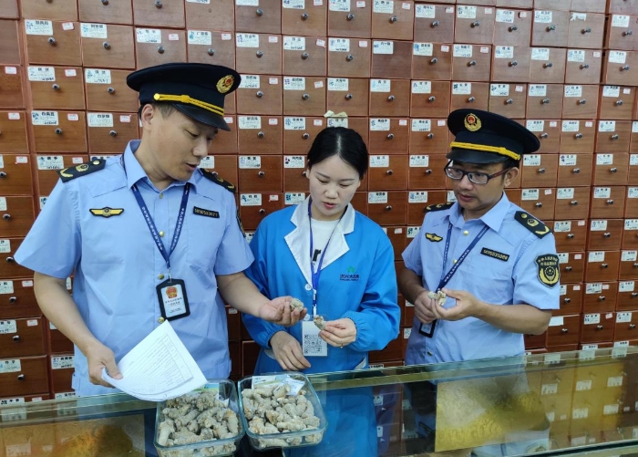 圖為執法人員在一零售藥店檢查中藥飲片質量情況。