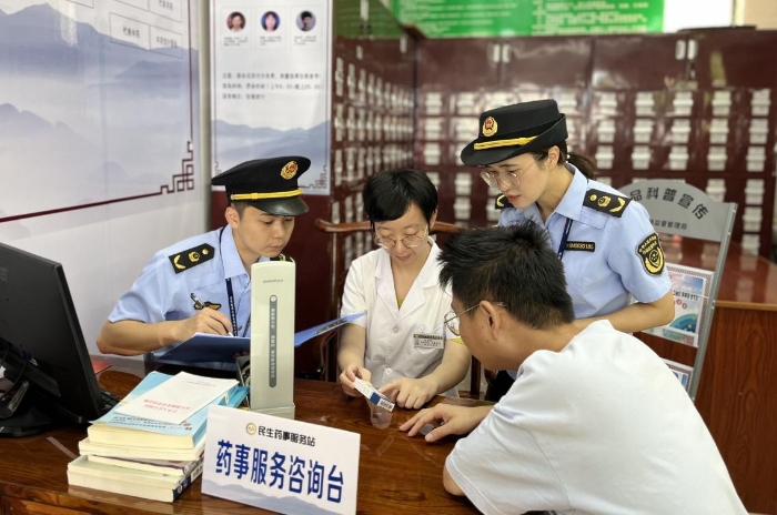圖為該局工作人員正在當地一家社區藥事服務站和當值醫護人員指導患者購藥用藥。
