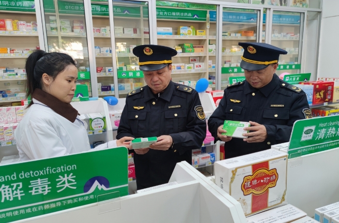 圖為執(zhí)法人員在藥店檢查抗病毒類藥品質量情況。