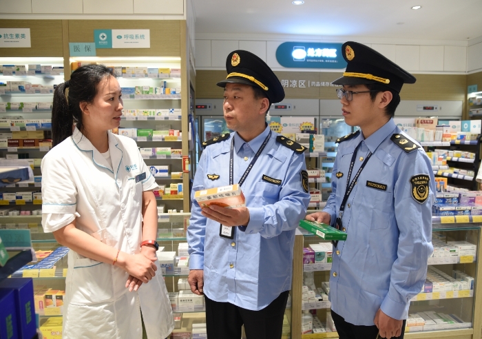 圖為執(zhí)法人員在一家藥店檢查藥品經(jīng)營情況。