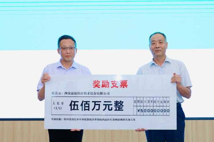 圖為研討會現場，陜西省藥監局二級巡視員王志宏向西安康拓醫療技術股份有限公司董事長胡立人頒發500萬元醫療器械創新獎勵資金。