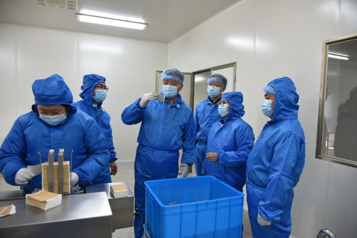 圖為甘肅省藥監(jiān)局黨組書記、局長吉永鋒（右四）帶領(lǐng)調(diào)研組在白銀振亞衛(wèi)生材料有限公司查看祖師麻關(guān)節(jié)止痛膏生產(chǎn)情況 。 （盧昌貴 攝）