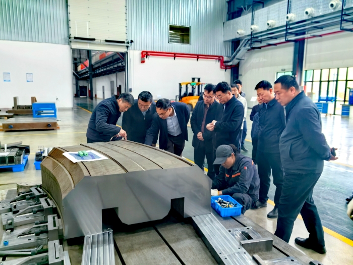 圖為中國工程院院士夏佳文為調(diào)研組講解重離子治療裝置偏轉(zhuǎn)磁鐵的部分組件。