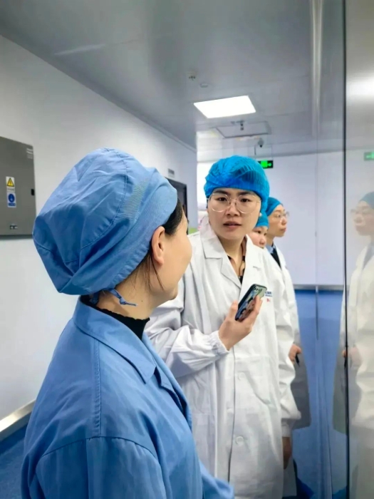 1月24日，中國醫(yī)藥報記者蔣紅瑜（右一）在桂林南藥生產(chǎn)車間采訪抗瘧藥品生產(chǎn)線改造情況